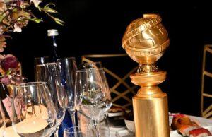 News Room : $125 Golden Globes menu leaves sour taste: Truth about Nobu dishes celebrities a guzzling down Elegant table setting with sushi, a gold award, and assorted dishes for a sophisticated dining experience.