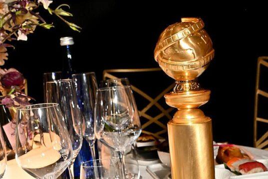 Elegant table setting with sushi, a gold award, and assorted dishes for a sophisticated dining experience.