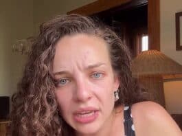 Upset woman with curly hair and blue eyes in a polka dot dress, indoors, emotional expression.