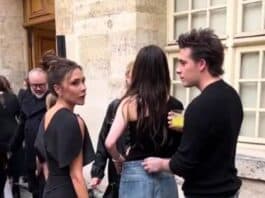 Discussions among stylish young adults at an outdoor event in a historic city setting.