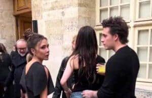 Discussions among stylish young adults at an outdoor event in a historic city setting.