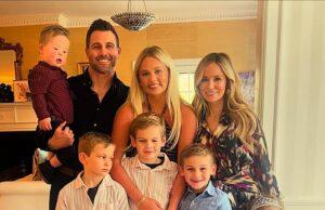 Happy family portrait of parents, kids, and baby celebrating indoors in bright, cozy home.