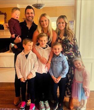 Happy family portrait of parents, kids, and baby celebrating indoors in bright, cozy home.