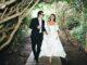 News Room : Brooklyn Beckham’s explosive claim his mother Victoria pulled out of designing Nicola Peltz’s wedding dress at the ‘eleventh hour’ is contradicted by bride’s stylist who said her couture Valentino gown took a YEAR to make Stylish couple walking through lush garden forest in elegant wedding attire, enjoying a romantic moment.