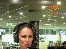 Woman broadcasting live at a radio station studio in a modern office environment.