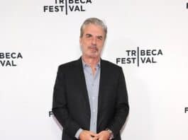 Stylish middle-aged man in black suit at Tribeca Festival red carpet event.