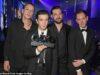 News Room : Have The 1975 split up? Band sends fans into meltdown after deleting Instagram grid and sharing ambiguous farewell post – four years after last album Men in formal suits accepting an award at a ceremony in a nightclub or event hall.