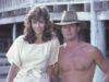 News Room : Inside The Thorn Birds’ Rachel Ward’s four-decade love story with co-star Bryan Brown, 78, and the secret to their long-lasting marriage – after actress, 68, responded to cruel trolling over her looks Young woman and shirtless man standing outdoors on wooden structure in vintage attire.