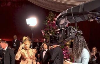 News Room : Jennifer Lopez’s ‘rude’ Glambot moment explained as Cole Walliser breaks silence to reveal what happened Elegant woman in glamorous gown being filmed at red carpet event with professional camera crew.