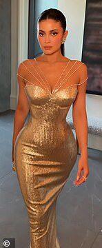 Glamorous woman in gold dress at a formal event.