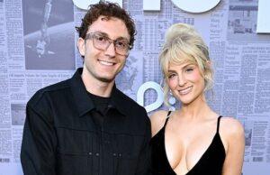 News Room : Meghan Trainor secretly welcomes third child with husband Daryl Sabara via surrogate… as couple gives first look at newborn daughter Smart man and woman posing for photo at media event in front of newspaper backdrop.