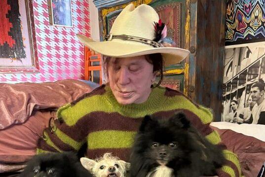 Pet-loving woman with three dogs in cozy room, showcasing a bond with her pets.