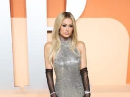 Elegant silver gown with black gloves on a glamorous woman at a fashion event.