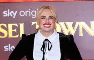 Blonde woman in black dress smiling at Lanka News Room event, showcasing fashion and entertainment coverage.