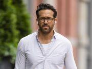 Stylish man walking outdoors in casual attire on city street.