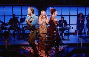 Performers on stage during a theatrical show in a vibrant, modern setting with live musicians in the background.